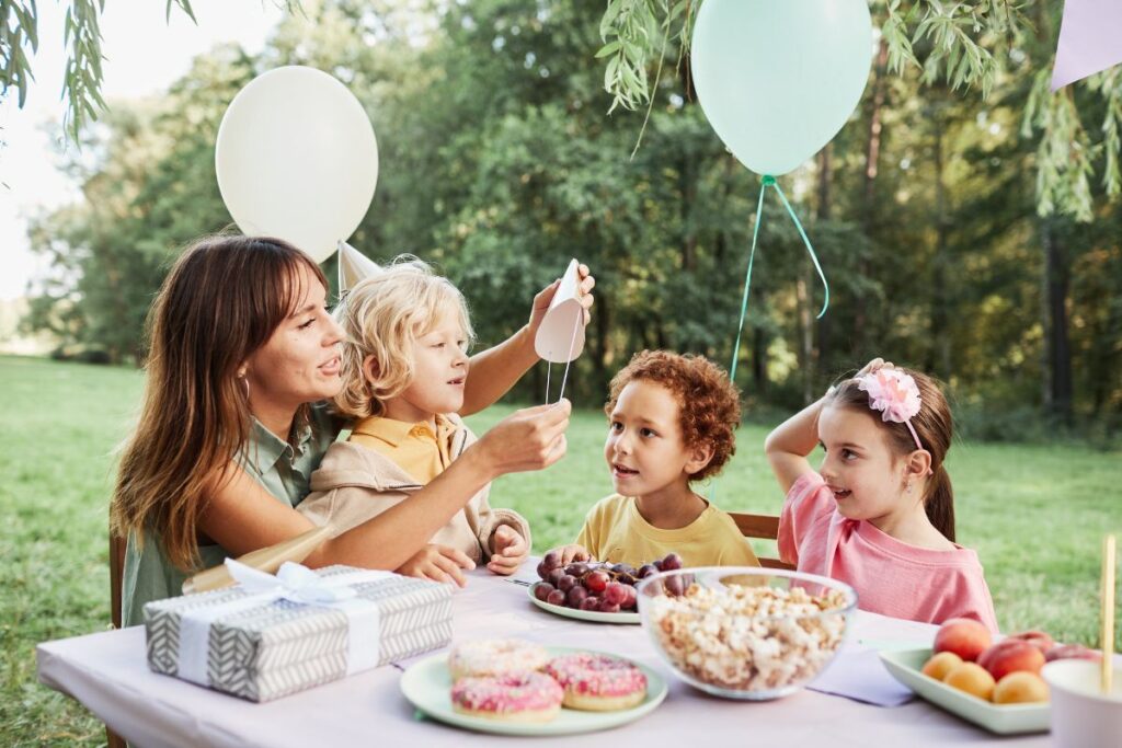 kids and mom at a birthday party enjoying snacks