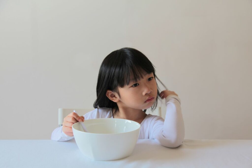 young child with empty bowl